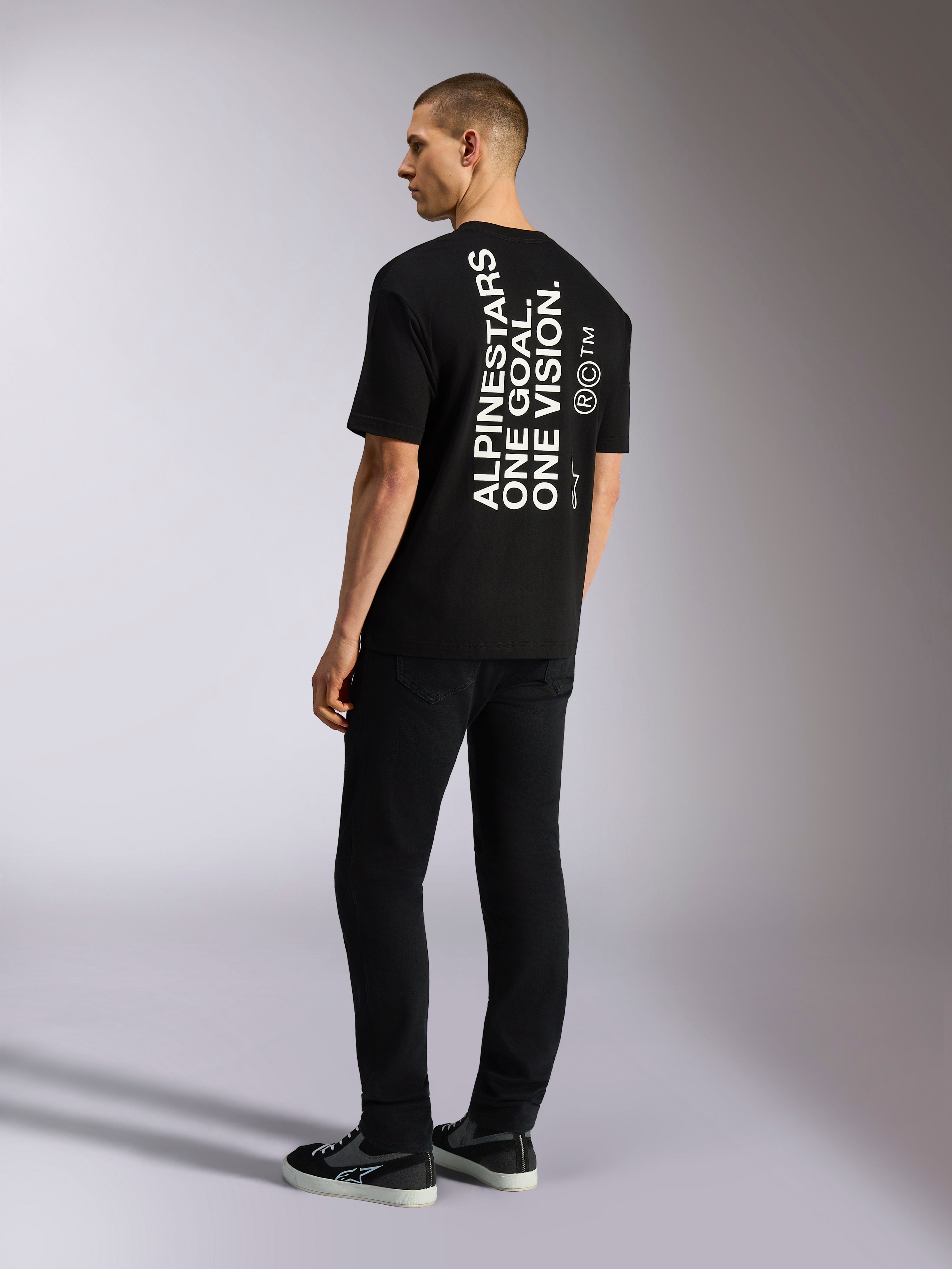 Alpinestars One Oversized CSF Tee, t-shirt à manches courtes, noir, vue de dos avec graphisme blanc vertical « ALPINESTARS ONE GOAL. ONE VISION. », coupe surdimensionnée, streetwear décontracté d'inspiration sport mécanique