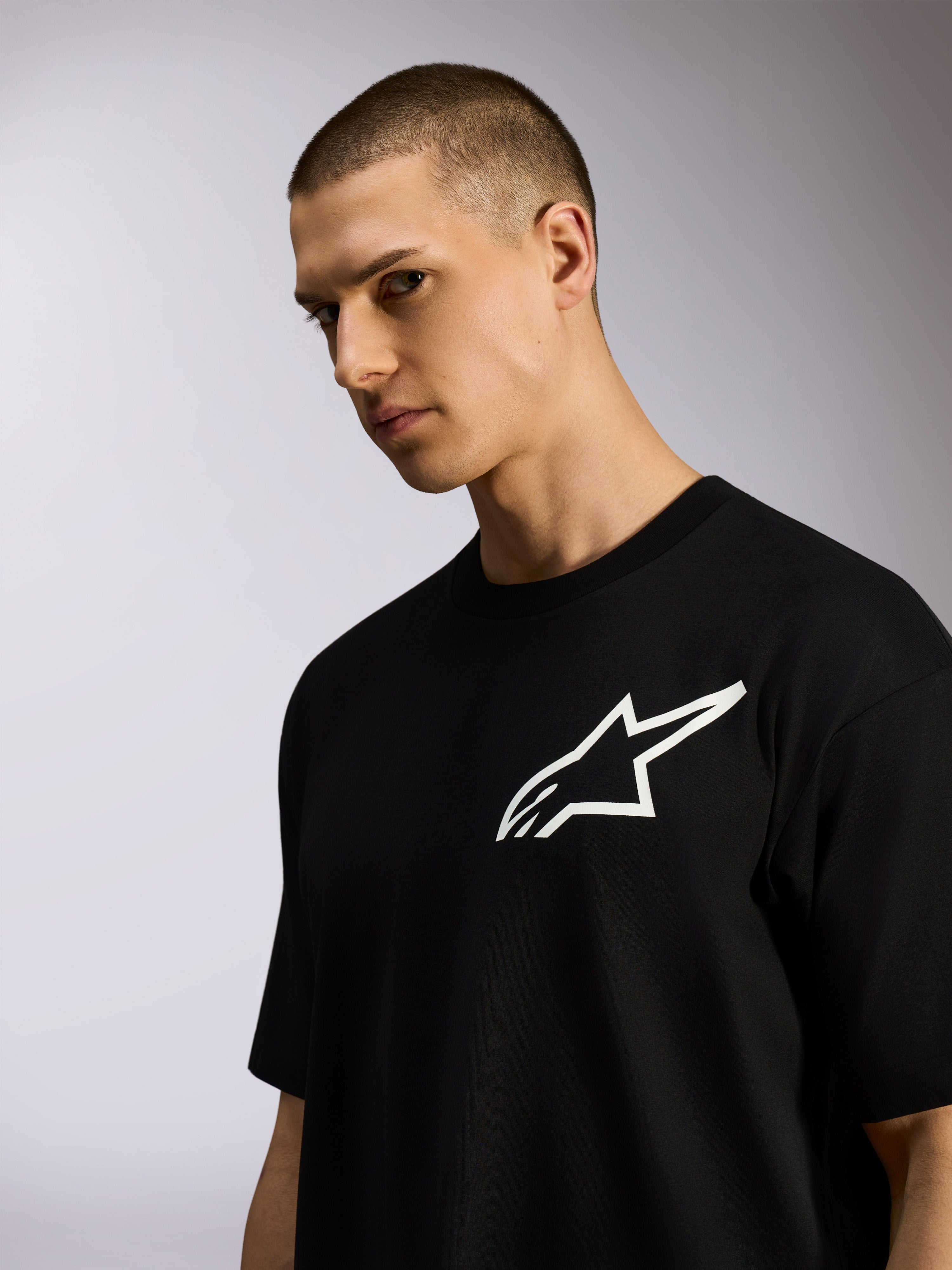 T-shirt Alpinestars One Oversized CSF, t-shirt à manches courtes, noir, logo Astars blanc, porté par un mannequin homme, style streetwear décontracté