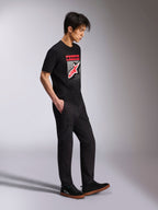 T-shirt Alpinestars Noka CSF, t-shirt à manches courtes, noir, logo Astars à l'avant avec dégradé MX rouge et blanc, porté avec un pantalon cargo noir et des baskets, streetwear décontracté inspiré des sports mécaniques
