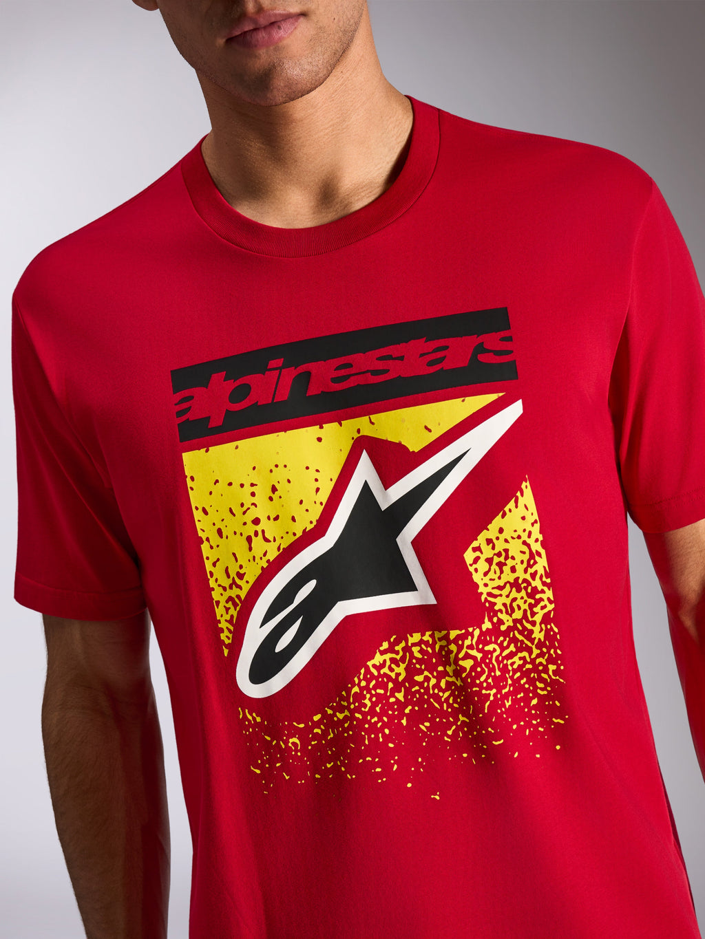 T-shirt Noka CSF Alpinestars, t-shirt à manches courtes, rouge, graphique sur le devant avec texte Alpinestars noir et logo Astars sur un motif moucheté jaune, streetwear de sport automobile décontracté