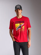 Alpinestars Noka CSF Tee, t-shirt à manches courtes, rouge, logo Astars à l'avant avec dégradé MX jaune, porté par un mannequin homme avec une casquette Alpinestars noire, style streetwear décontracté.
