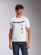T-shirt Alpinestars Abus CSF, t-shirt à manches courtes, blanc, logo Alpinestars incurvé avec graphismes multiples empilés sur la poitrine, porté par un mannequin avec un jean en denim foncé, streetwear décontracté motorsport