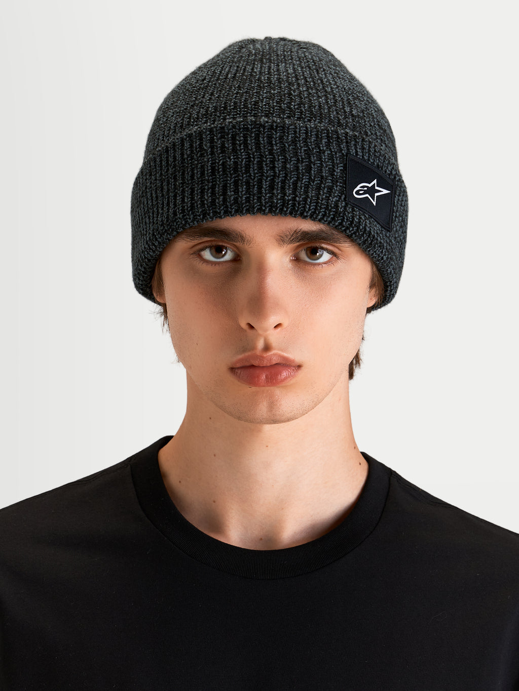 Alpinestars Bonnet Unload Rib Cuff, bonnet sportswear en maille côtelée gris chiné, porté par un modèle, avec un écusson tissé SAstars