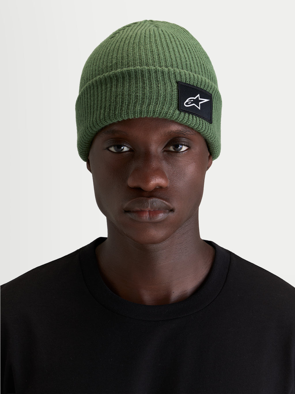 Bonnet Unload Rib Cuff d'Alpinestars, bonnet sportswear en maille côtelée vert, coupe peu profonde avec écusson tissé SAstars sur le devant, porté par un modèle