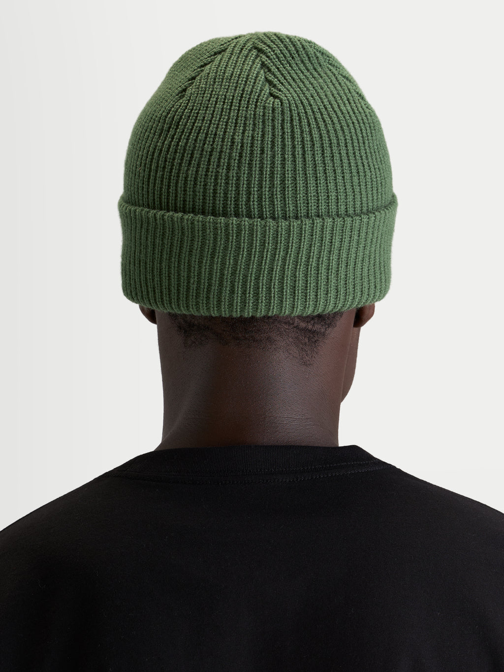 Bonnet Unload Rib Cuff d'Alpinestars, bonnet sportswear en maille acrylique vert pois, vue de dos sur un modèle portant un t-shirt noir
