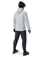 Veste thermique Alpinestars A-Dura en Titanium, vue arrière d'un cycliste portant une veste thermique à capuche gris clair, accompagnée d'un casque de VTT noir, de gants noirs et d'un pantalon gris foncé, équipement de VTT fonctionnel.