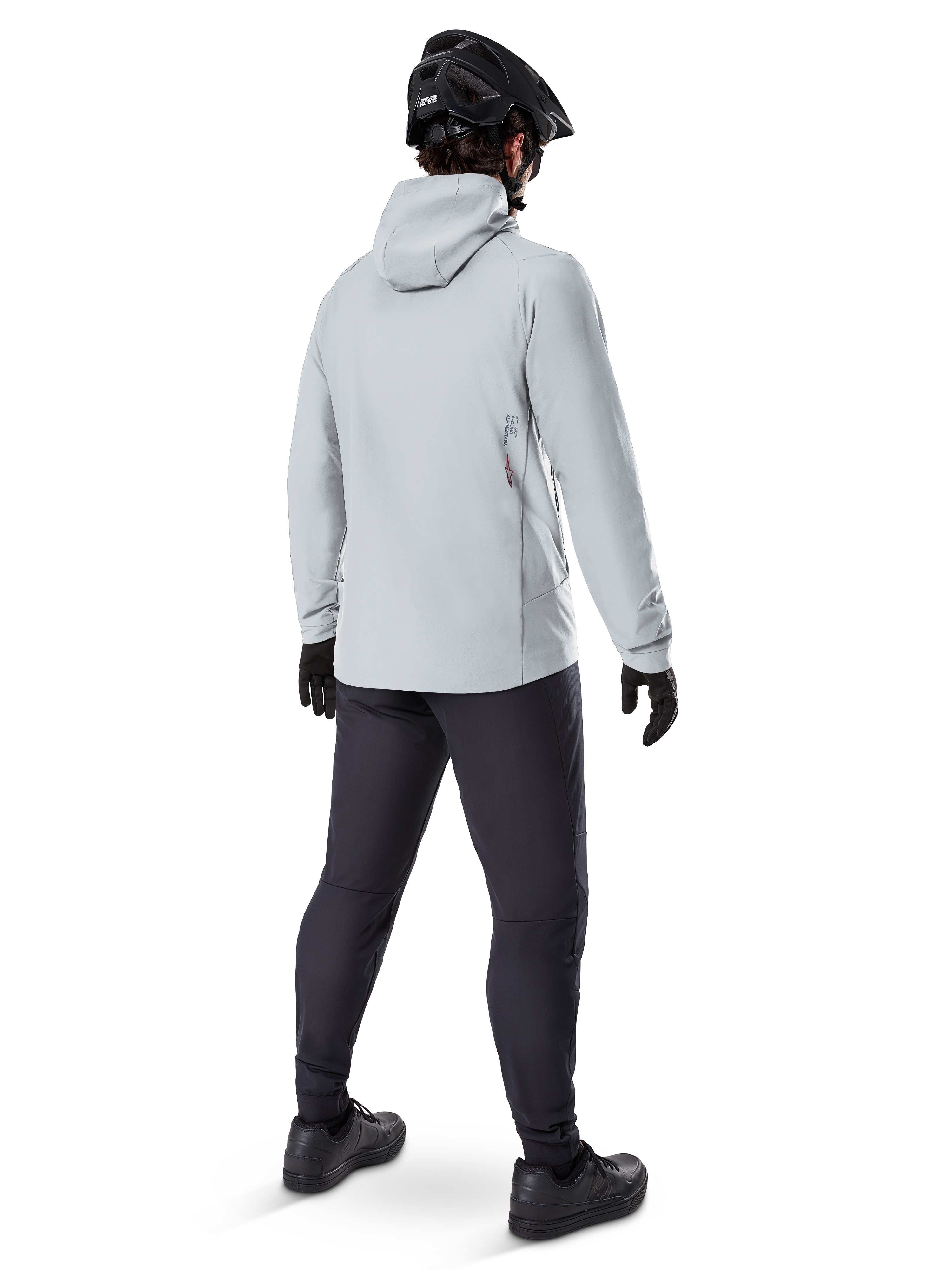 Veste thermique Alpinestars A-Dura en Titanium, vue arrière d'un cycliste portant une veste thermique à capuche gris clair, accompagnée d'un casque de VTT noir, de gants noirs et d'un pantalon gris foncé, équipement de VTT fonctionnel.