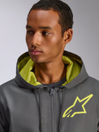Veste coupe-vent Alpinestars Speeder Chromium, gris anthracite avec des accents jaune fluo, logo étoile jaune sur la poitrine et doublure de capuche en mesh assortie, coupe-vent léger décontracté