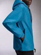 Veste coupe-vent Alpinestars Speeder Chromium, coupe-vent léger à capuche bleu, vue de profil présentant des poignets élastiques et des poches repose-mains, capuche réglable avec cordons de serrage, design décontracté inspiré du sport automobile