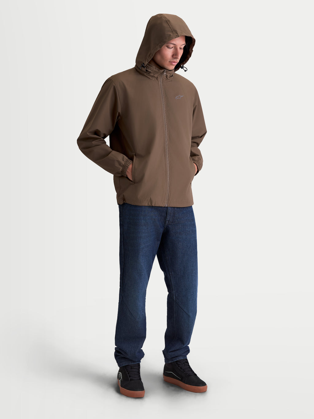 Alpinestars Veste Overhaul Racer, veste de sportswear légère pour homme, marron, avec capuche et logo Astars sur la poitrine, tenue décontractée portée par un modèle.
