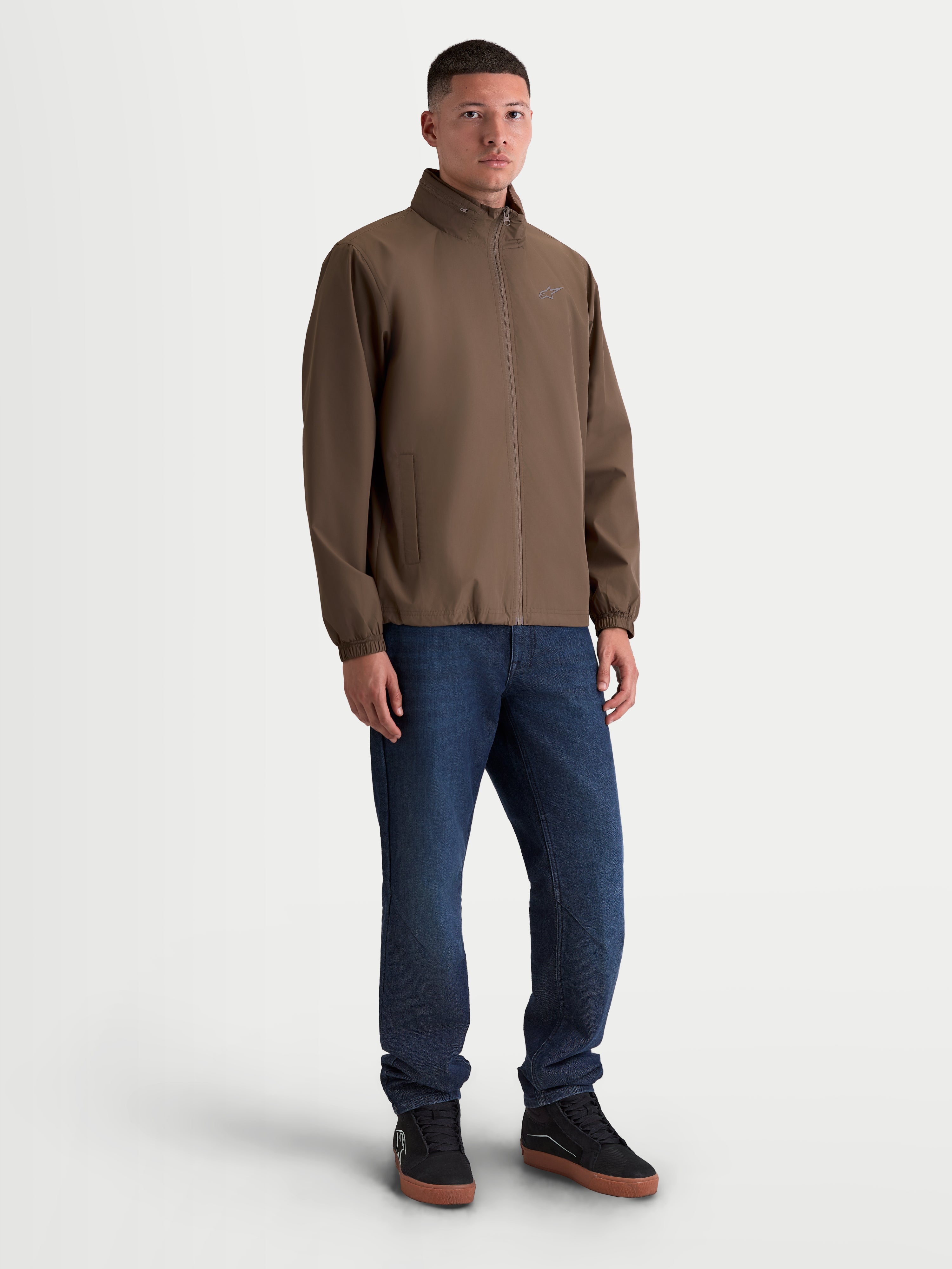 Alpinestars Overhaul Racer, veste sportswear légère pour homme, marron, silhouette épurée inspirée du sport automobile, logo Astars discret sur la poitrine et capuche dissimulée dans le col.