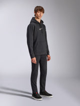 Alpinestars Frontal Hoodie, Noir, sweat à capuche en polaire avec logo HD blanc sur la poitrine et logos sur les manches, poche kangourou, porté avec un pantalon noir et des baskets, style streetwear décontracté inspiré du sport automobile