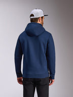 Sweat à capuche Frontal Alpinestars, sweat en polaire bleu marine, vue de dos d'une tenue streetwear décontractée, porté avec un pantalon noir et une casquette mesh blanche et noire, design moderne inspiré des sports mécaniques