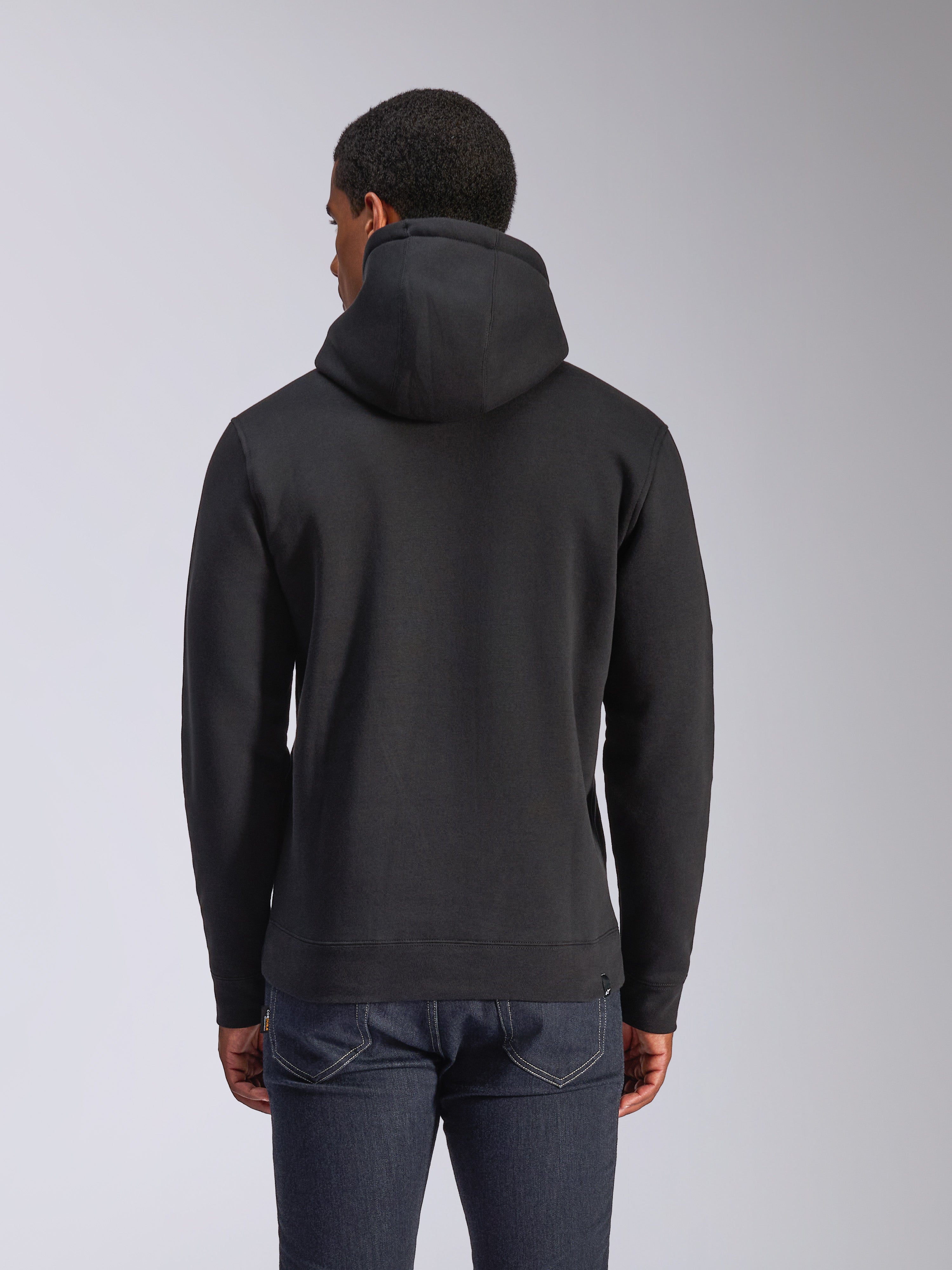 Alpinestars Blaze V3 Hoodie, vue arrière d'un sweat à capuche noir en polaire, style streetwear décontracté, avec poignets et ourlet côtelés, capuche doublée en jersey, porté avec un jean bleu foncé
