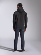 Sweat à capuche Alpinestars Blaze V3, style streetwear décontracté, noir, vue de dos d'un sweat à capuche en polaire, porté avec un jean denim bleu foncé et des chaussures noires, design épuré inspiré des sports mécaniques