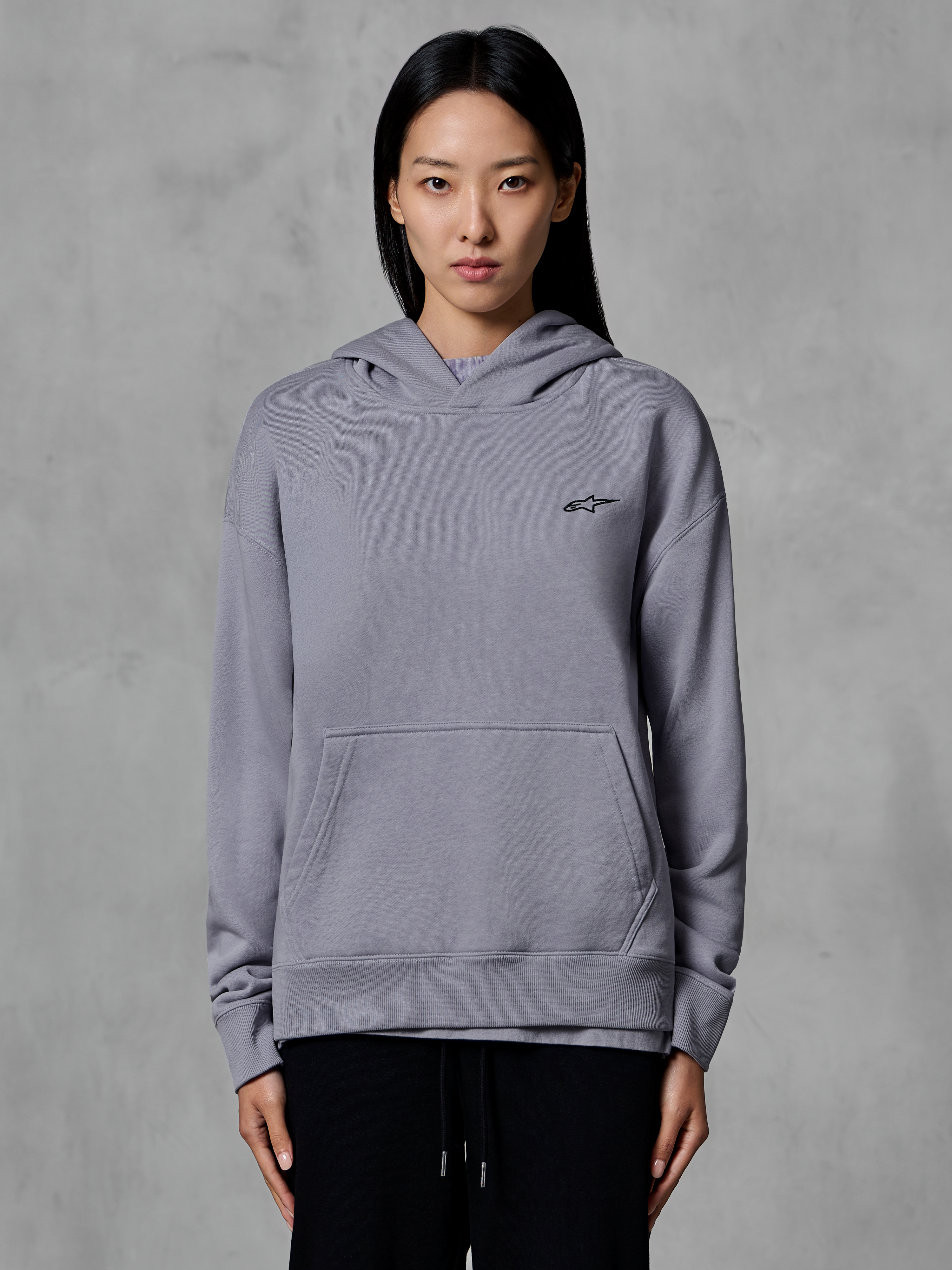 Alpinestars Essentials Ageless Hoodie, sportswear décontracté, argent avec petit logo noir, poche kangourou, sweat à capuche, porté par un mannequin, vêtement lifestyle moderne