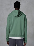 Sweat à capuche zippé Alpinestars Essentials Ageless, vue de dos sur modèle, vert Cactus, streetwear décontracté inspiré du sport automobile, coupe décontractée avec ourlet et poignets côtelés, polaire compacte de haute qualité