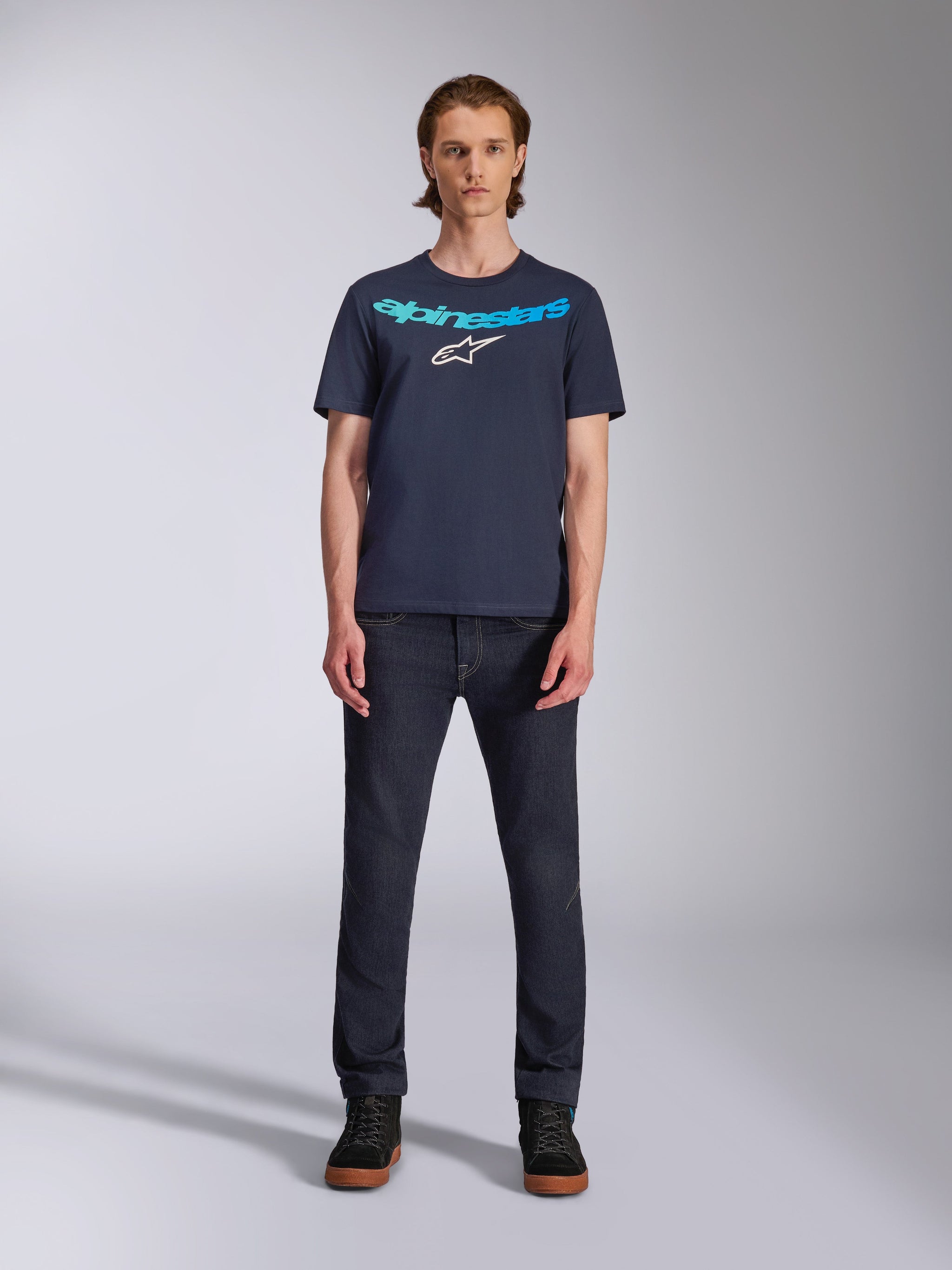 Alpinestars Collared CSF Tee, Short Sleeve T-Shirt, Navy Blue, featuring light blue Alpinestars text and white star logo on chest, worn by model with dark denim jeans, casual motorsport streetwear