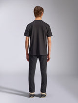 Alpinestars Fasting CSF Tee, t-shirt à manches courtes, noir, vue de dos sur mannequin, porté avec un pantalon noir et des baskets, streetwear décontracté d'inspiration sport automobile