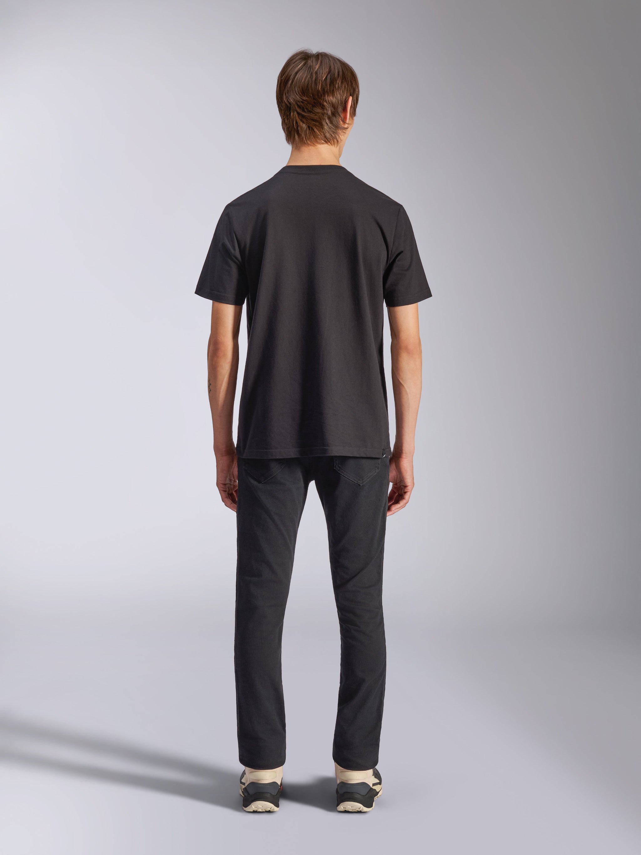 Alpinestars Fasting CSF Tee, t-shirt à manches courtes, noir, vue de dos sur mannequin, porté avec un pantalon noir et des baskets, streetwear décontracté d'inspiration sport automobile