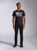 Alpinestars Waving CSF Tee, Short Sleeve T-Shirt, Black, featuring a white distressed flag-style graphic on the chest, worn by a model with black pants and black high-top sneakers, Casual Motorsport Streetwear