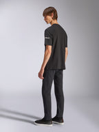 T-shirt Alpinestars Frontal CSF, t-shirt à manches courtes, noir, marquage astars blanc sur la manche, porté par un mannequin avec un pantalon et des chaussures noirs, design décontracté inspiré du sport automobile