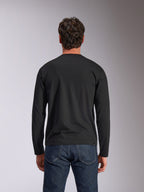 T-shirt à manches longues Alpinestars Trackside CSF, noir, vue de dos, porté avec un jean en denim bleu foncé, streetwear décontracté inspiré du sport automobile