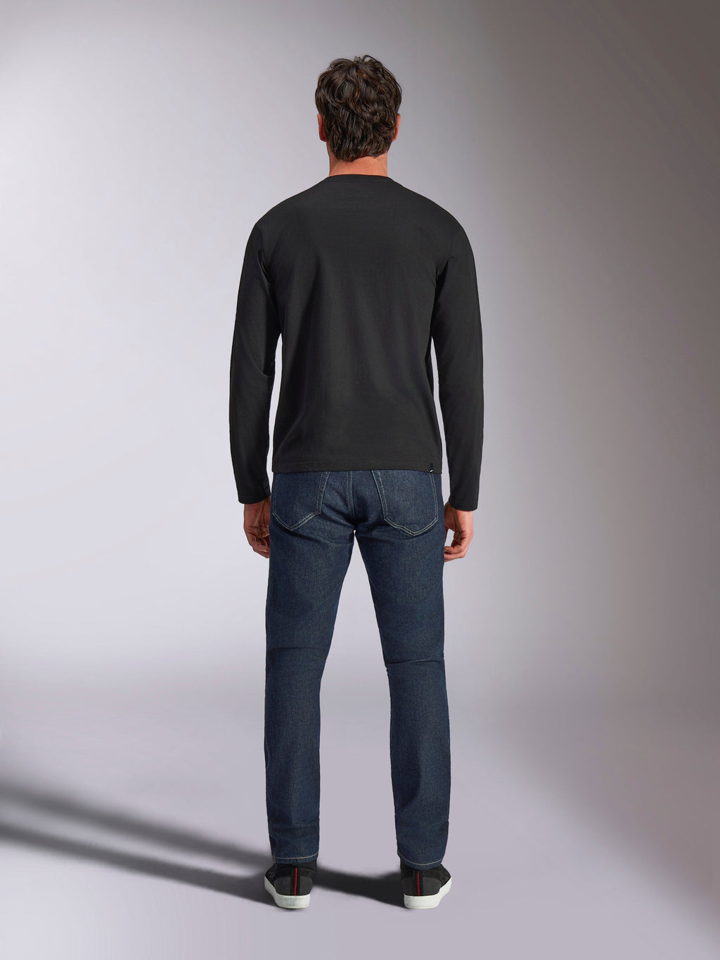 Alpinestars Trackside CSF Tee, t-shirt à manches longues, noir, vue de dos sur un mannequin portant un jean en denim bleu foncé, streetwear décontracté inspiré du sport automobile