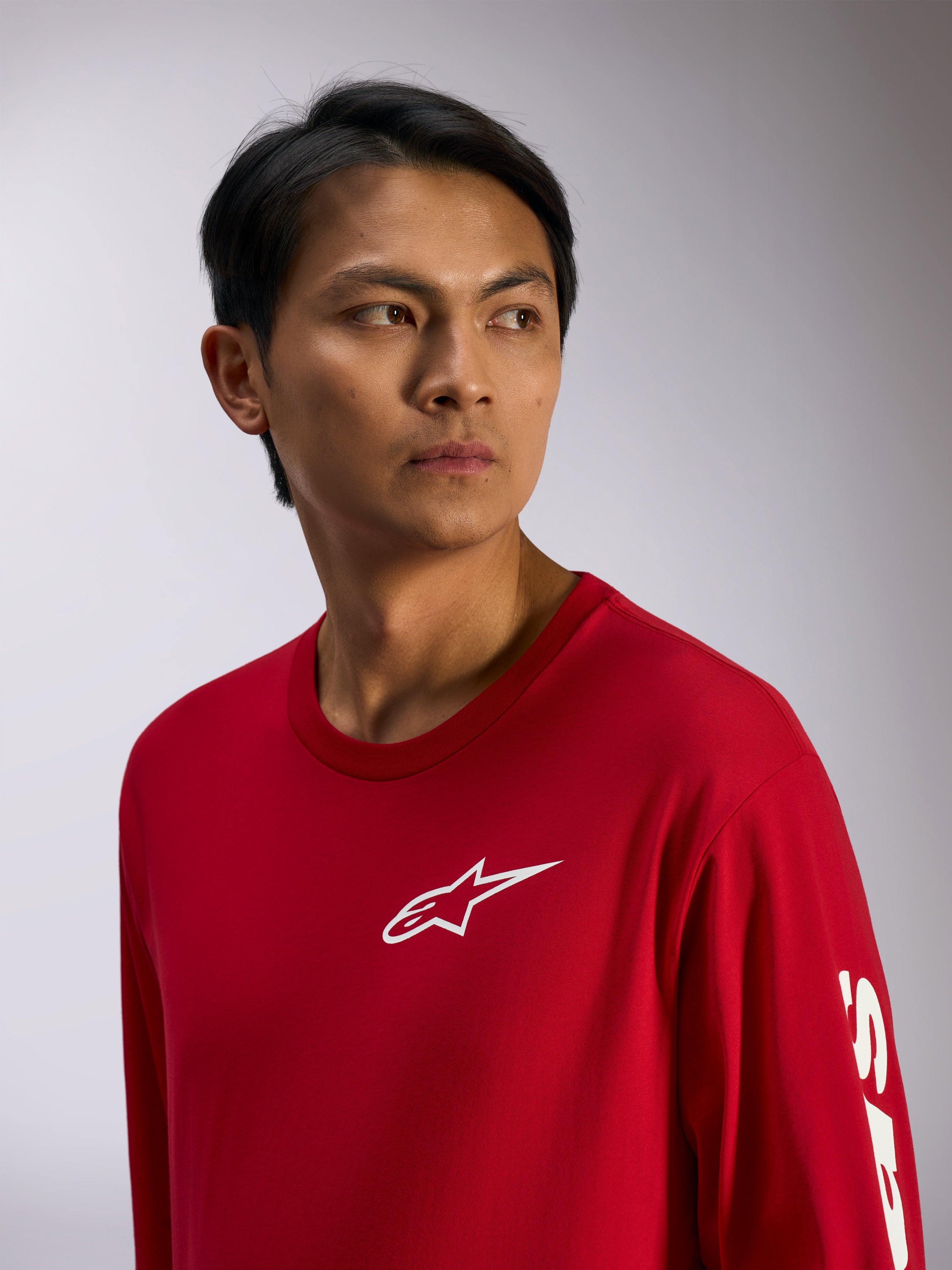 Alpinestars Trackside CSF Tee, t-shirt à manches longues, rouge avec logo Alpinestars blanc sur la poitrine et lettrage sur la manche, streetwear motorsport décontracté, portrait lifestyle