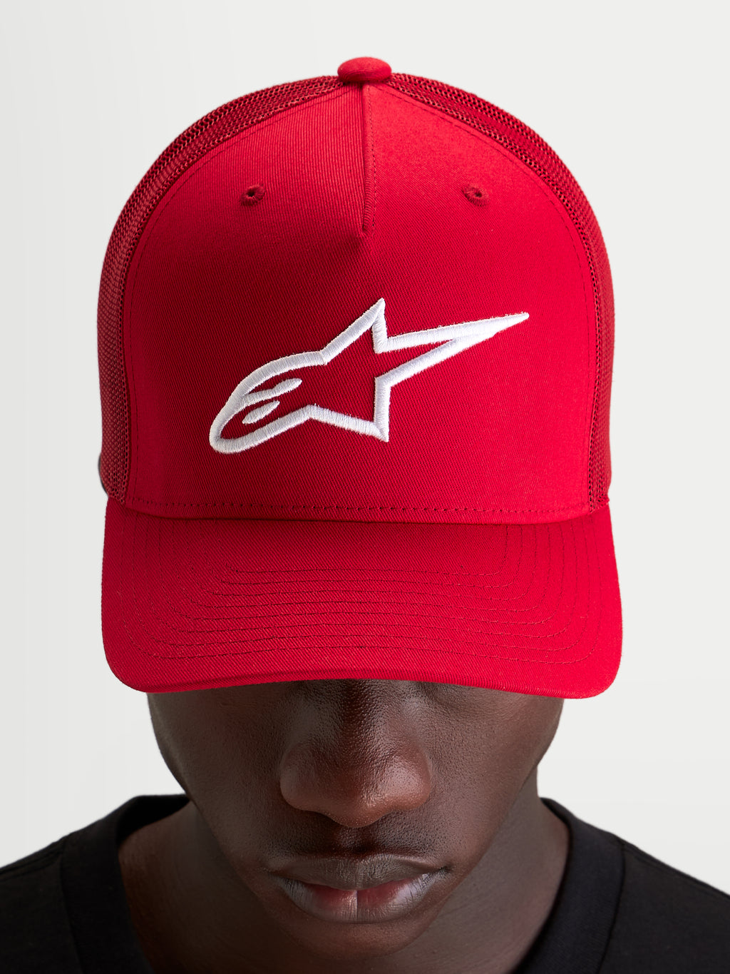 Casquette Snapback Ageless Alpinestars, casquette sportswear rouge avec logo Astars brodé blanc, couronne structurée et visière incurvée portée par un modèle