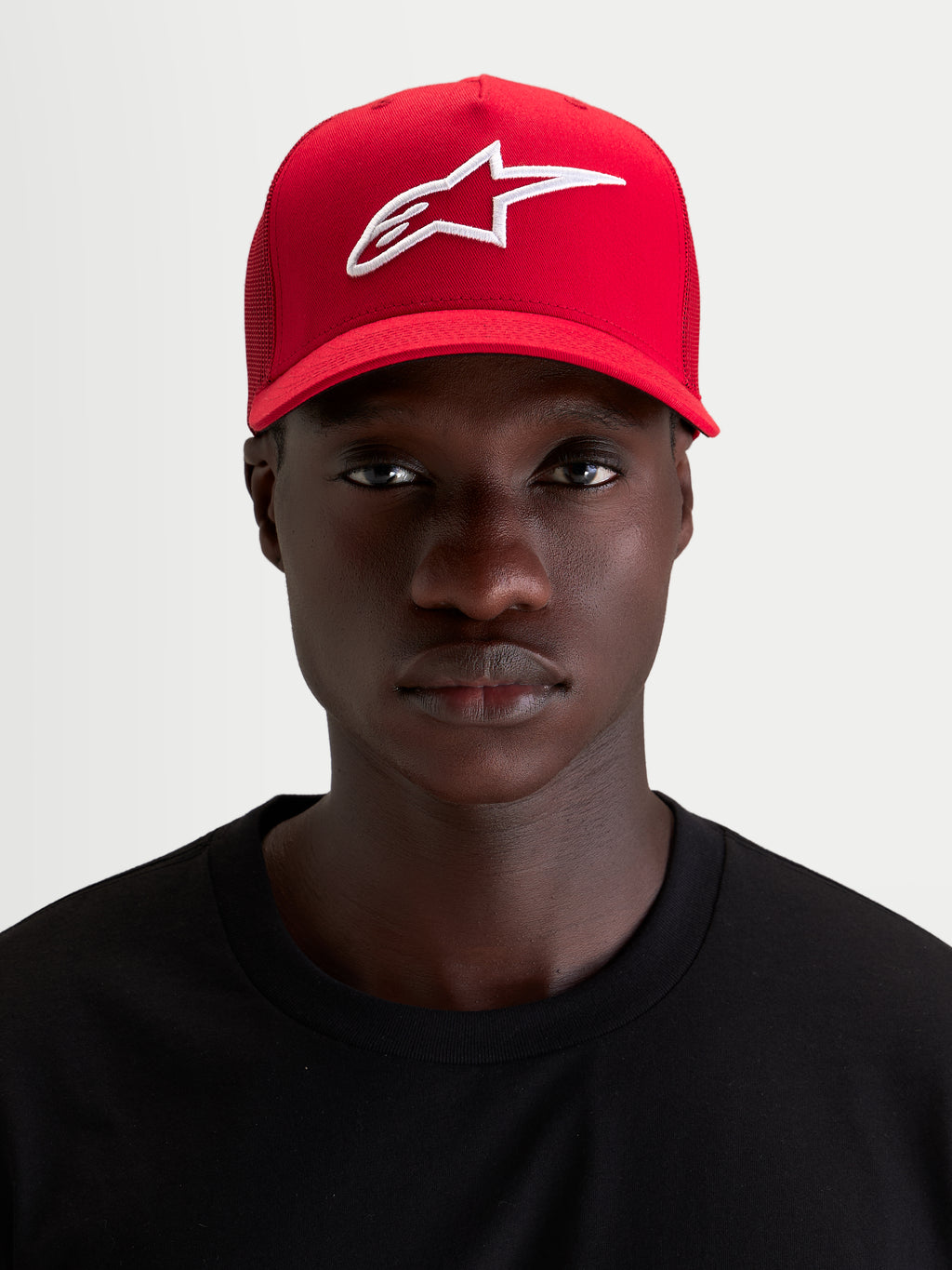 Alpinestars Casquette Snapback Ageless, casquette de sport rouge avec logo Astars brodé en blanc, visière incurvée et couronne structurée, portée par un modèle