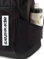 Sac à dos Alpinestars Defcon V3, sac à dos quotidien noir, gros plan sur la poche latérale en maille avec bouteille d'eau, logo vertical blanc sur le devant, matériau en polyester 600D durable