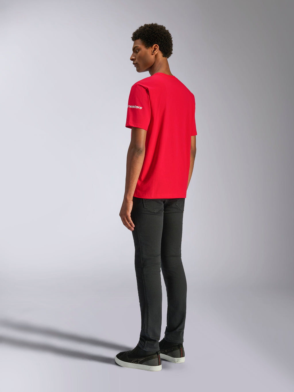 T-shirt Alpinestars Frontal CSF, t-shirt à manches courtes, rouge, vue de dos sur mannequin, avec logo blanc sur la manche, associé à un pantalon noir, vêtement streetwear décontracté haute performance