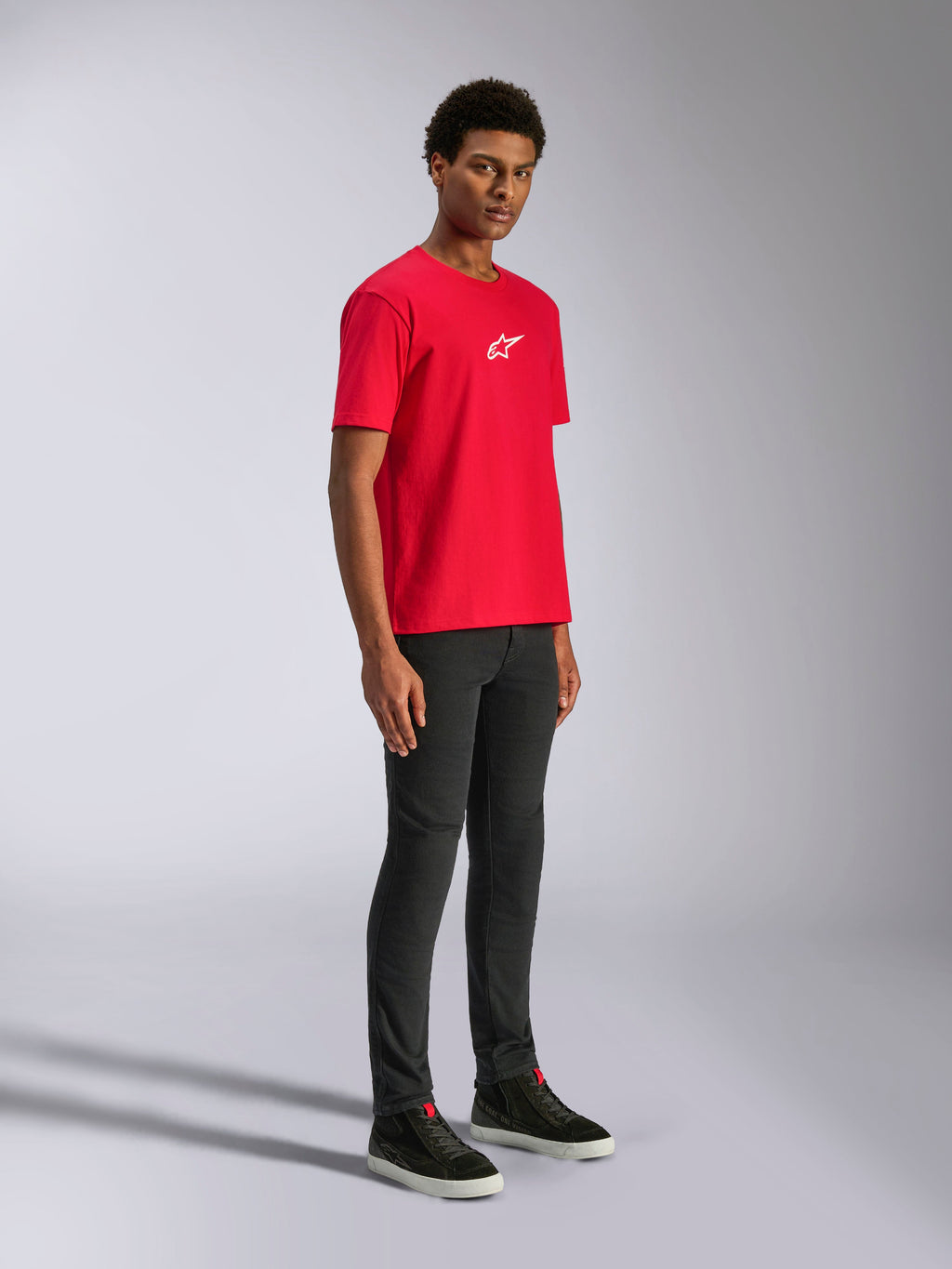 T-shirt Alpinestars Frontal CSF, t-shirt à manches courtes, rouge, logo étoile blanc sur la poitrine, porté par un mannequin avec pantalon noir et baskets noires, streetwear décontracté performance sport automobile