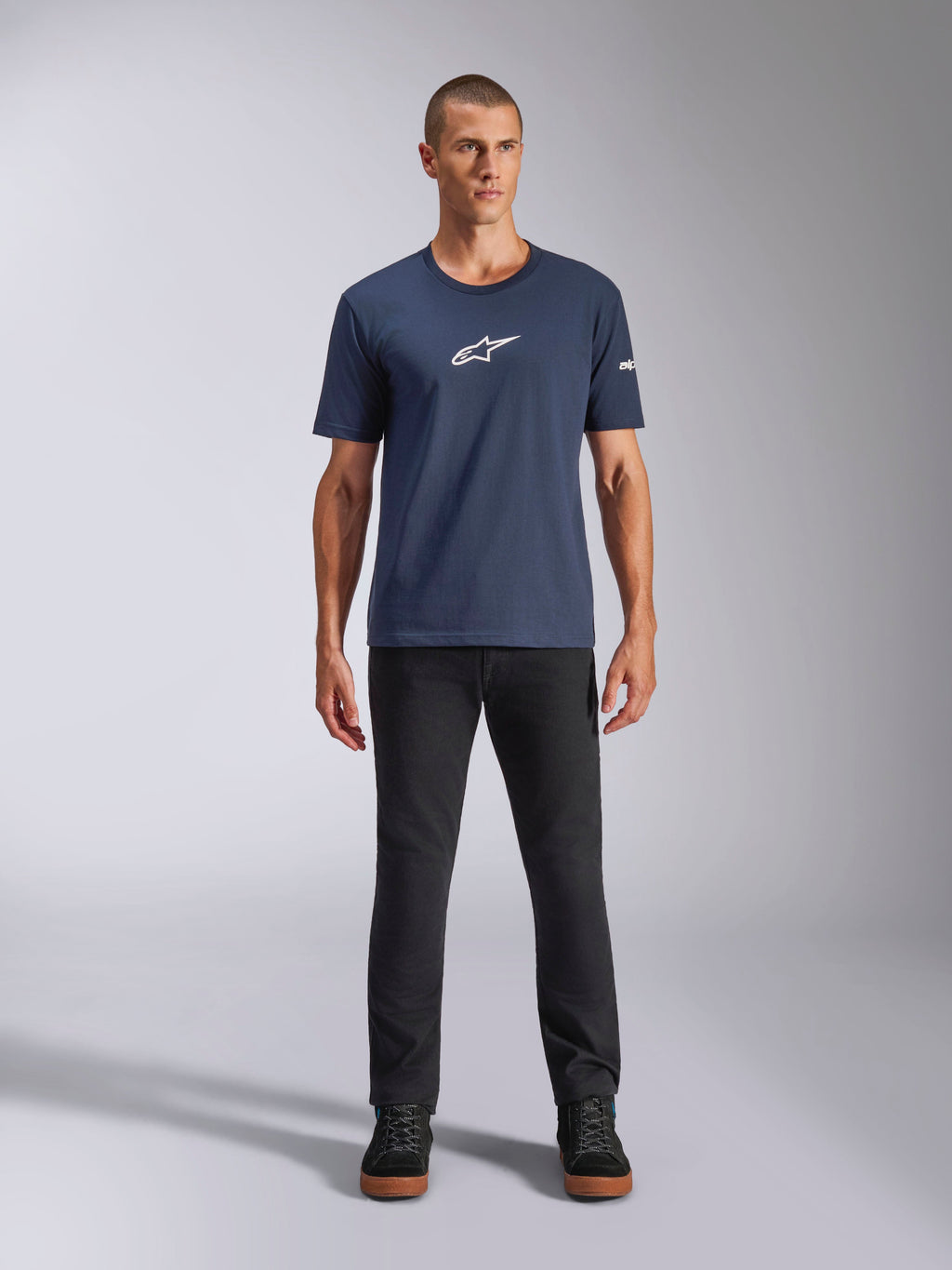Alpinestars Frontal CSF Tee, t-shirt à manches courtes, bleu marine, logo étoile Alpinestars blanc sur la poitrine, porté avec un pantalon noir et des baskets, sportswear de performance décontracté
