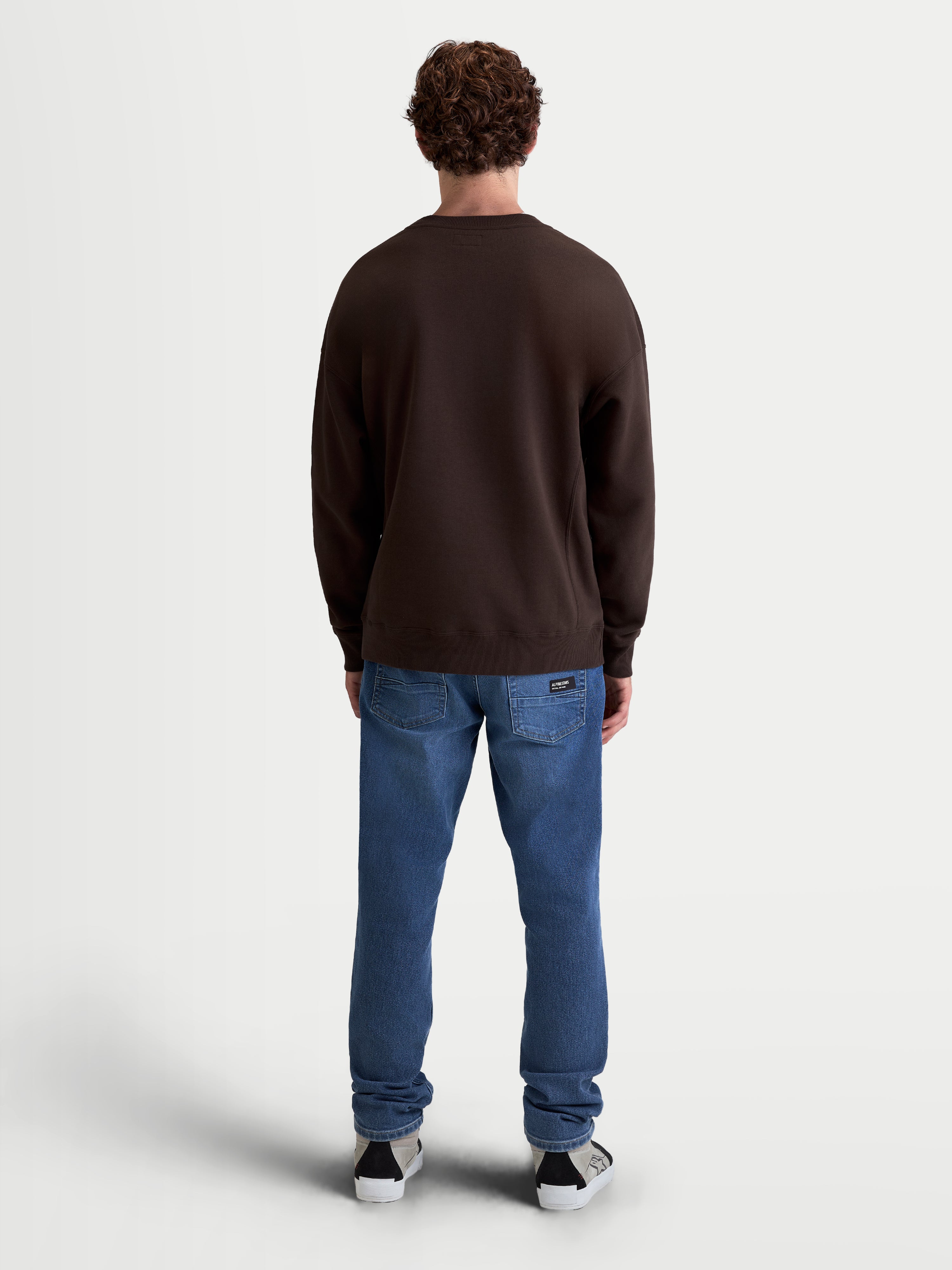 Alpinestars Guise Oversize Sweat, pull en polaire marron, style sportswear décontracté, vue de dos sur modèle, confectionné en mélange de coton et polyester recyclé avec poignets et ourlet côtelés.