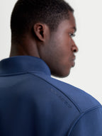 Alpinestars Sweat Apera Half-Zip, pull de sportswear pour homme, bleu acier, vue arrière rapprochée montrant le logo Alpinestars HD ton sur ton sur l'épaule et le tissu en polaire premium.