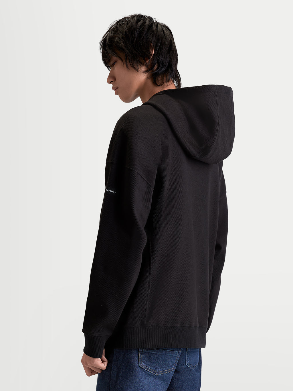 Alpinestars Sweat À Capuche Textured Oversize Camino, sweat à capuche sportswear pour homme, noir, polaire texturée en maille sergée, vue de dos montrant une silhouette décontractée, col haut et étiquette tissée sur la manche