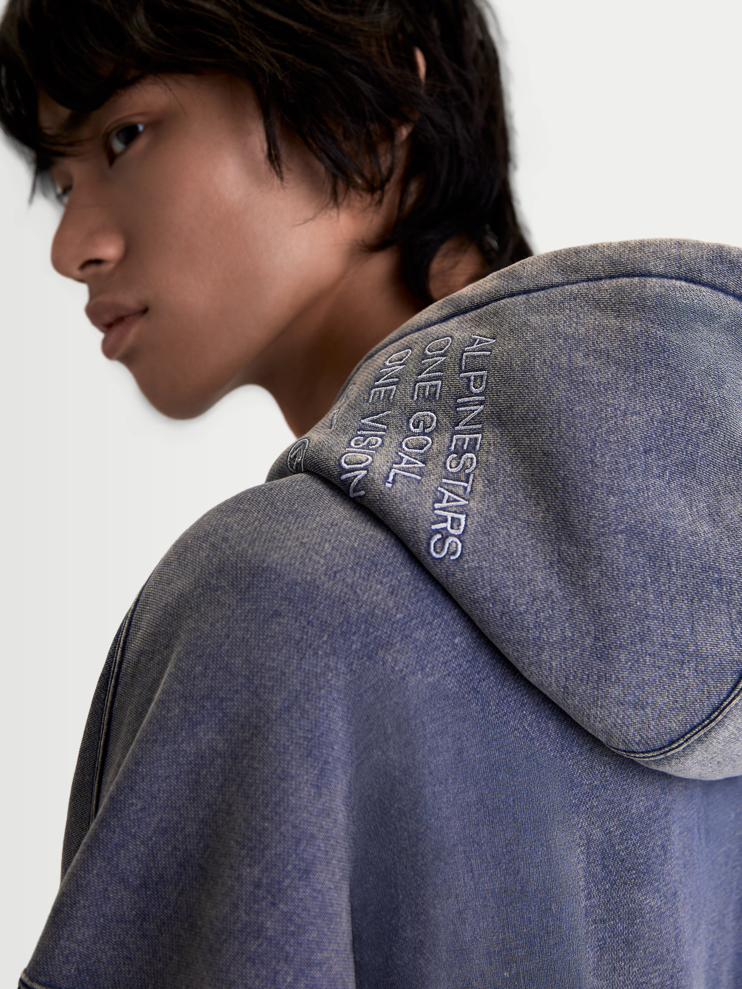 Alpinestars Infinite Washed Oversized Hoodie, Sportswear Pullover for Men and Women, Washed Navy Blue, close-up view of the hood showing the 'ONE GOAL. ONE VISION.' embroidery and the textured snow-wash finish on the fleece material.