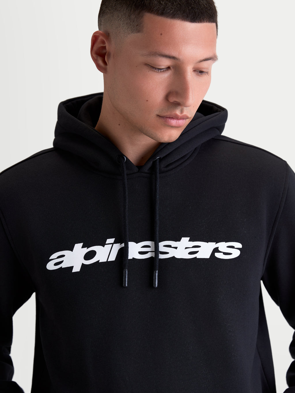 Alpinestars Sweat À Capuche Race Wordmark, sweat à capuche sportswear pour homme, noir avec logo wordmark blanc sur la poitrine, capuche doublée et cordons avec embouts trempés, confectionné en polaire de coton et polyester recyclé.
