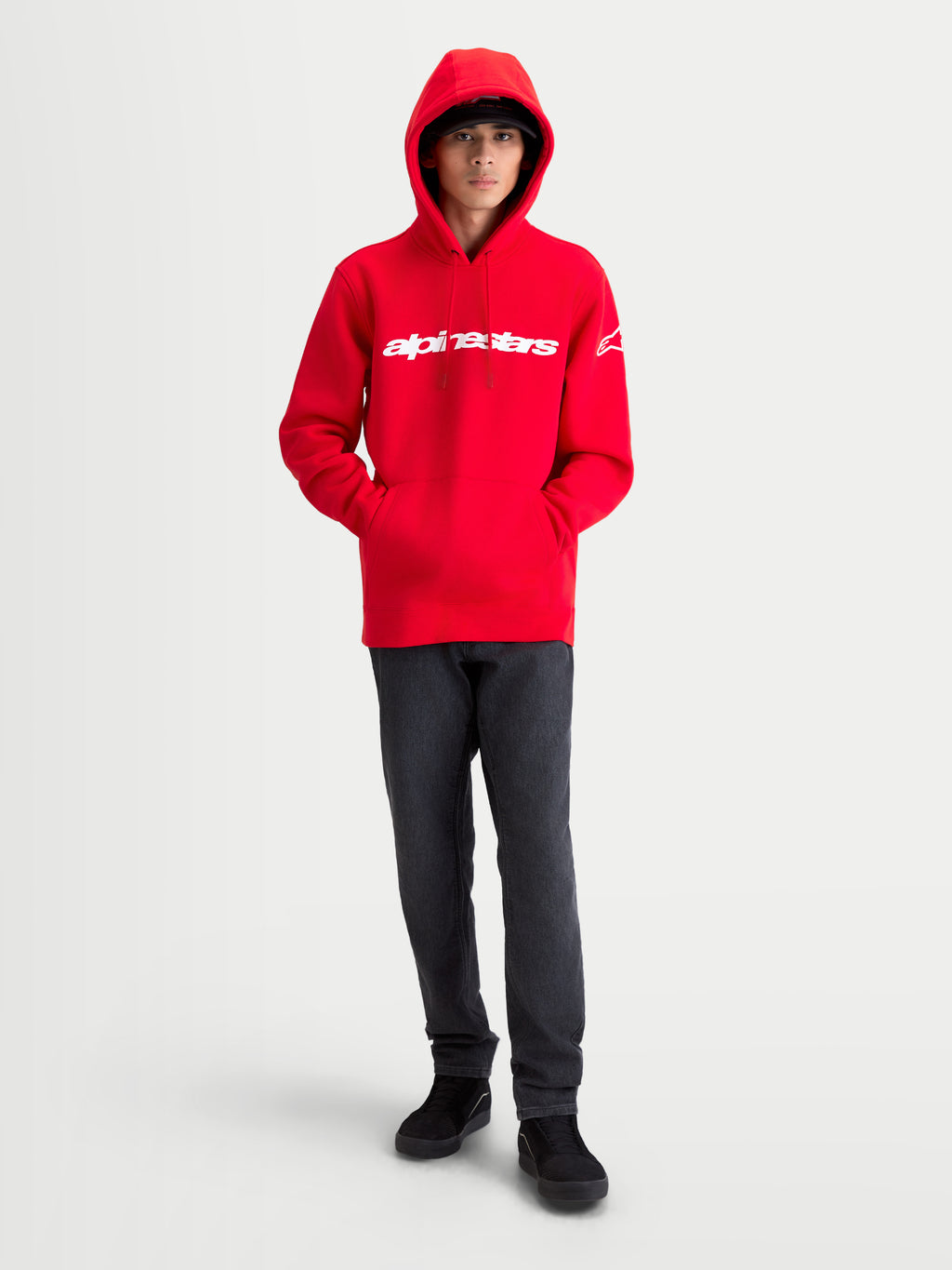 Alpinestars sweat à capuche Race Wordmark, sweat à capuche polaire pour homme, rouge et blanc, vue de face sur modèle avec logo Alpinestars linéaire sur la poitrine et logo Ageless sur la manche, style sportswear décontracté