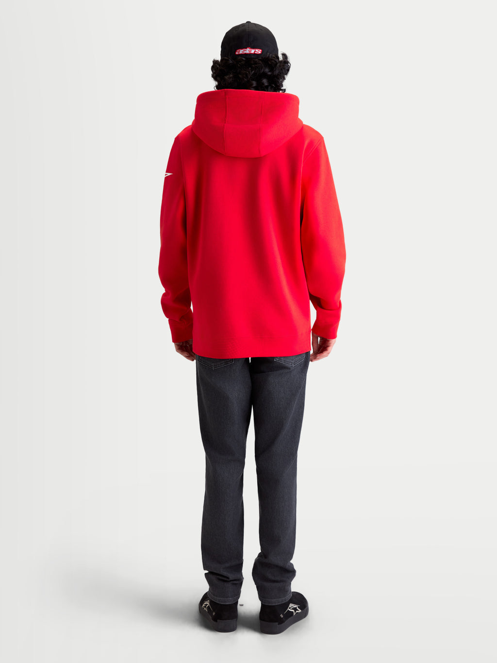 Alpinestars Sweat à capuche Race Wordmark, sweat à capuche polaire rouge avec accents blancs, vue de dos sur modèle avec capuche doublée et logo Ageless sur la manche, vêtement motorsport décontracté