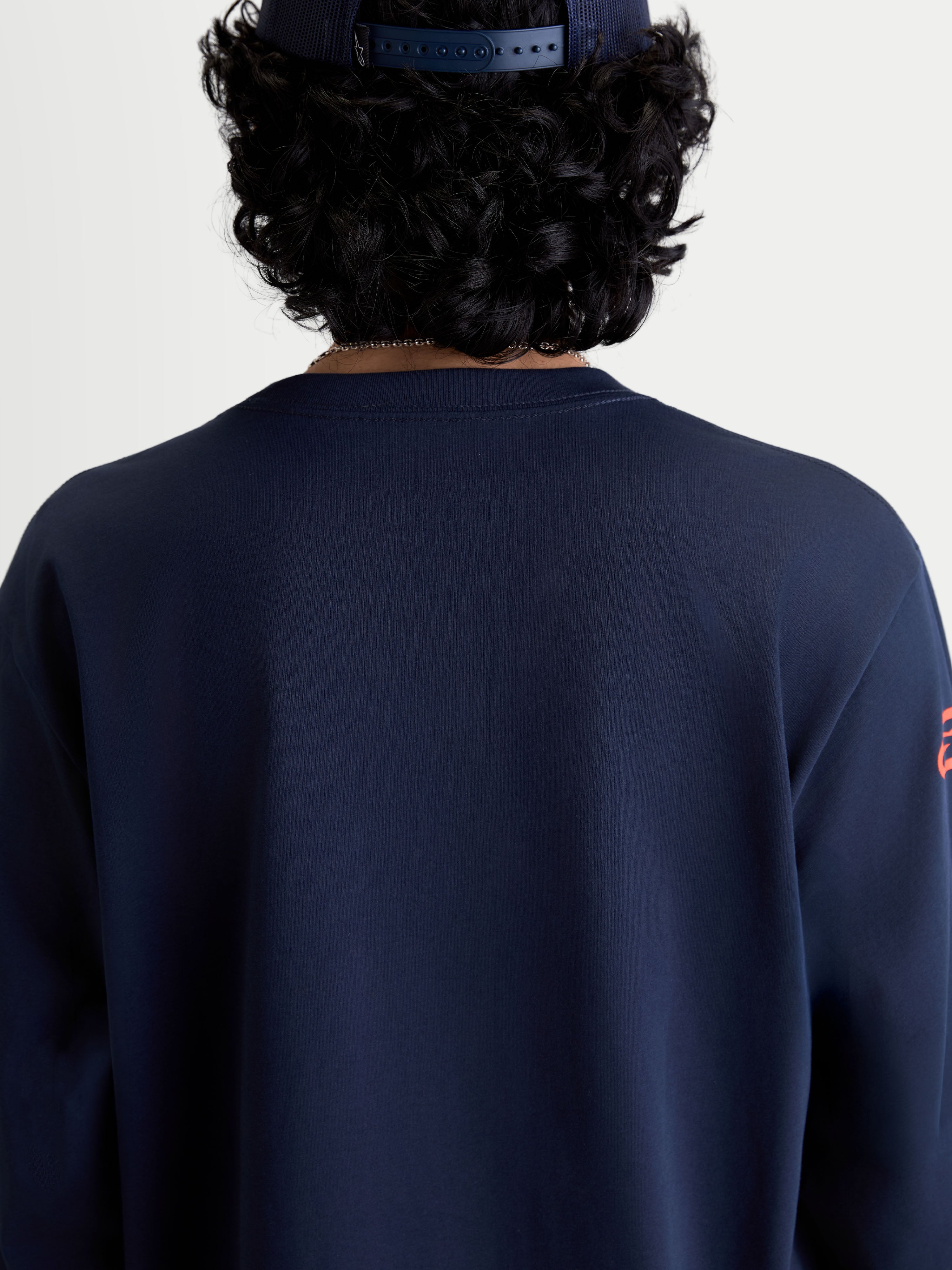 Alpinestars T-Shirt Velocifier CSF, t-shirt de sportswear à manches longues bleu marine, vue de dos sur modèle avec col rond côtelé, vêtement décontracté inspiré du sport automobile en mélange de coton et polyester recyclé