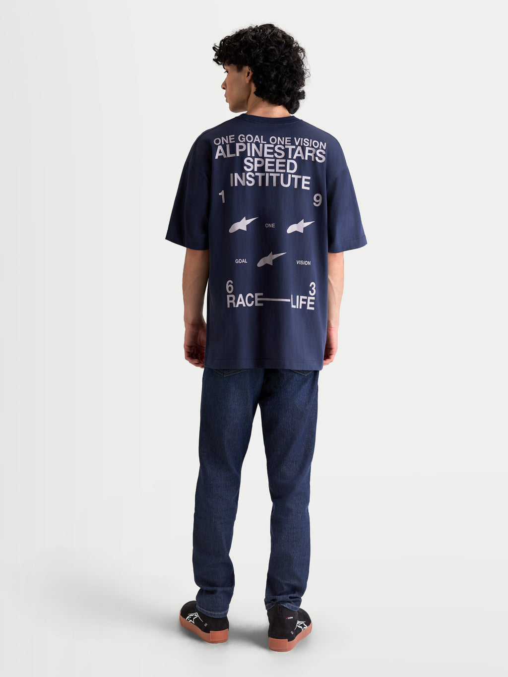 Alpinestars Institute Oversized SS CSF Tee, t-shirt sportswear à manches courtes bleu marine avec grand graphique blanc au dos, texte Alpinestars Speed Institute, slogan One Goal One Vision, coupe oversize décontractée, vue de dos sur mannequin