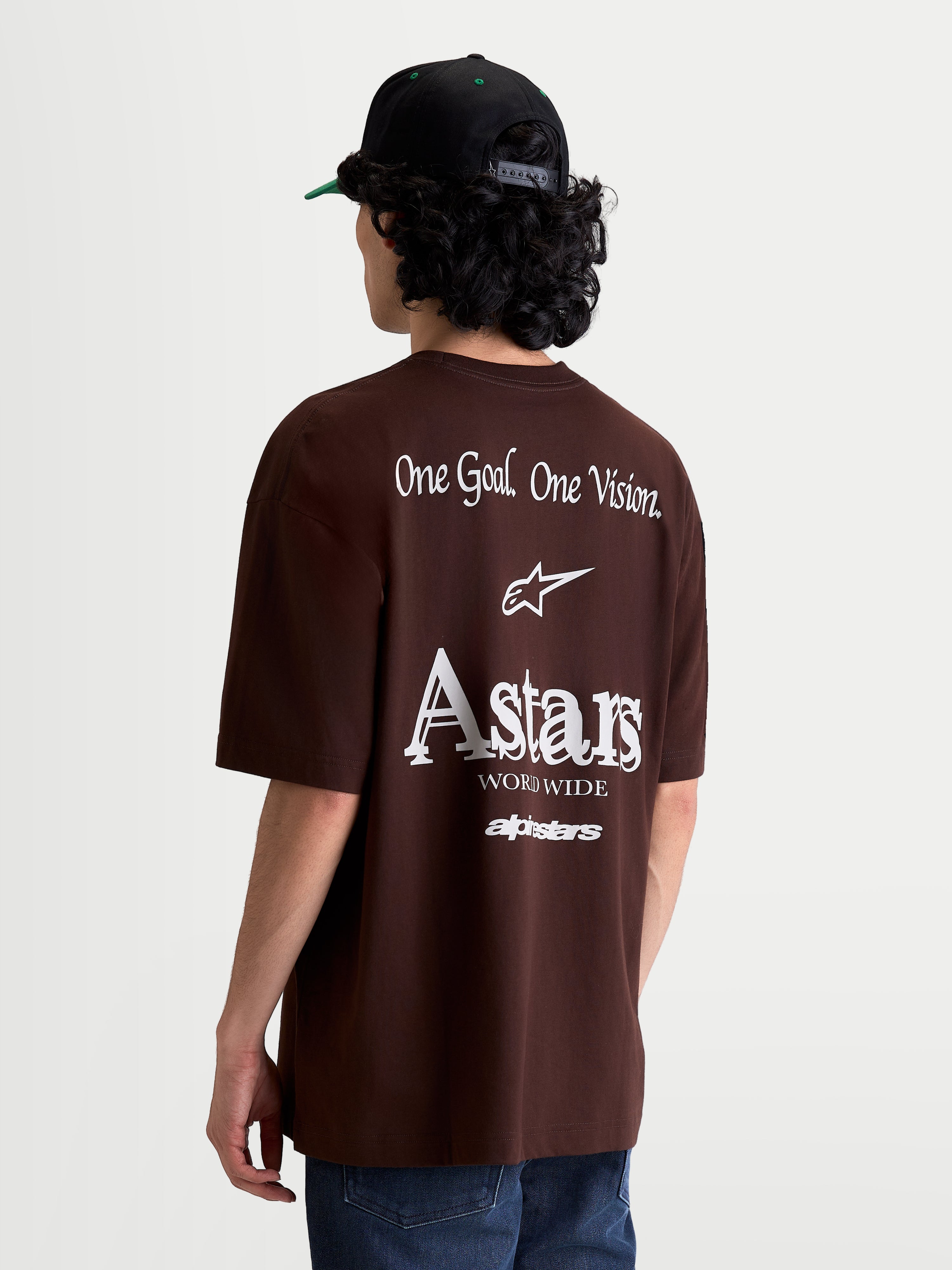 Alpinestars T-Shirt Post Oversized CSF, t-shirt de sportswear à manches courtes marron, vue de dos sur mannequin mettant en avant les logos blancs One Goal. One Vision. et Astars, coupe oversize, vêtement décontracté en mélange de coton et polyester