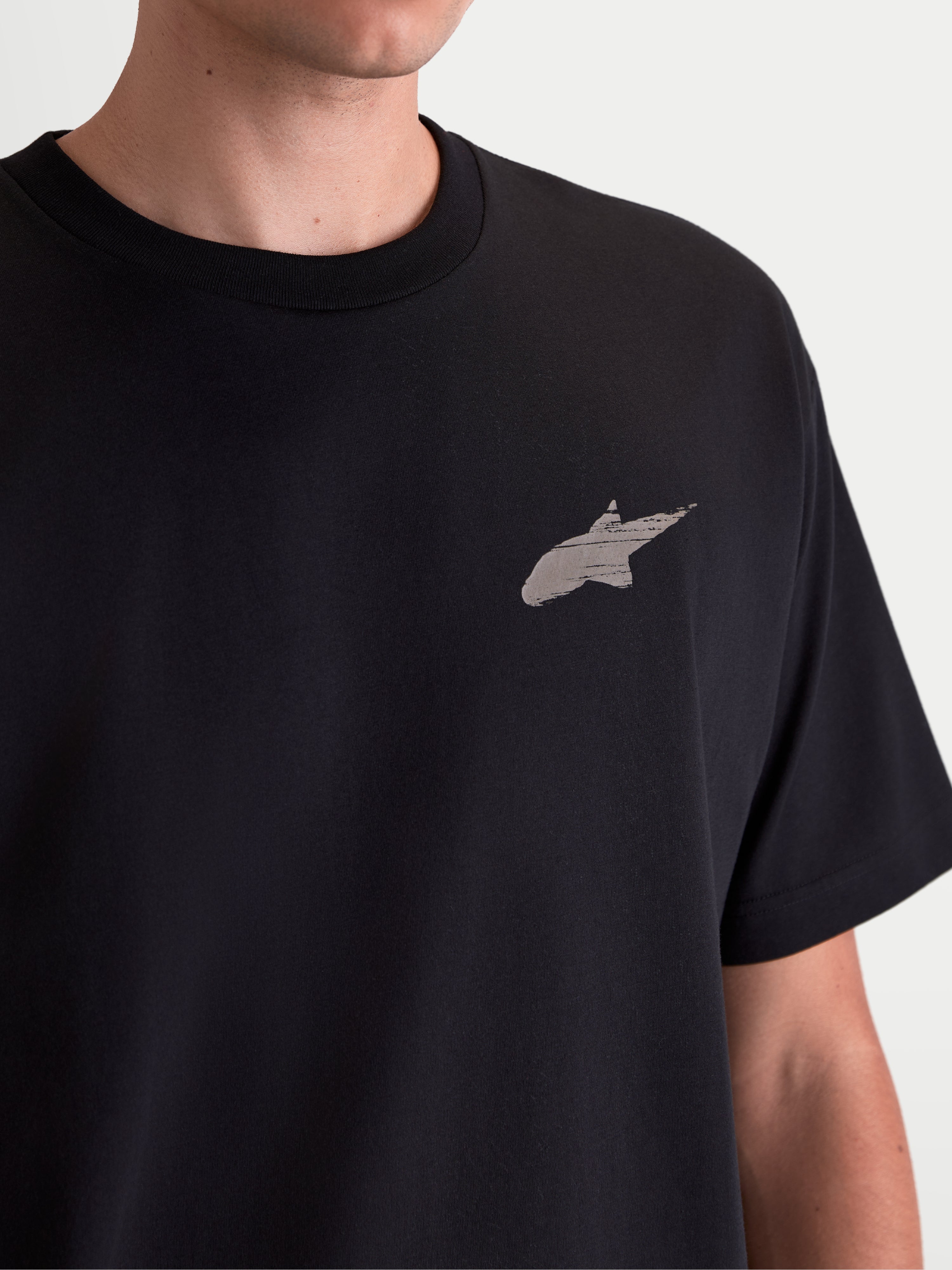 Alpinestars T-Shirt Checkback Oversized CSF, t-shirt sportswear oversize, noir, gros plan de la poitrine avec le logo Astars gris à impression douce, mélange de coton et polyester, style motorsport décontracté