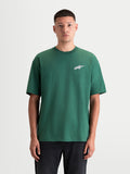 Alpinestars Checkback Oversized CSF, t-shirt de sportswear à manches courtes pour homme, vert et blanc, vue de face sur modèle avec une coupe large décontractée et le logo Astars sur la poitrine, haut en mélange coton-polyester inspiré du motorsport