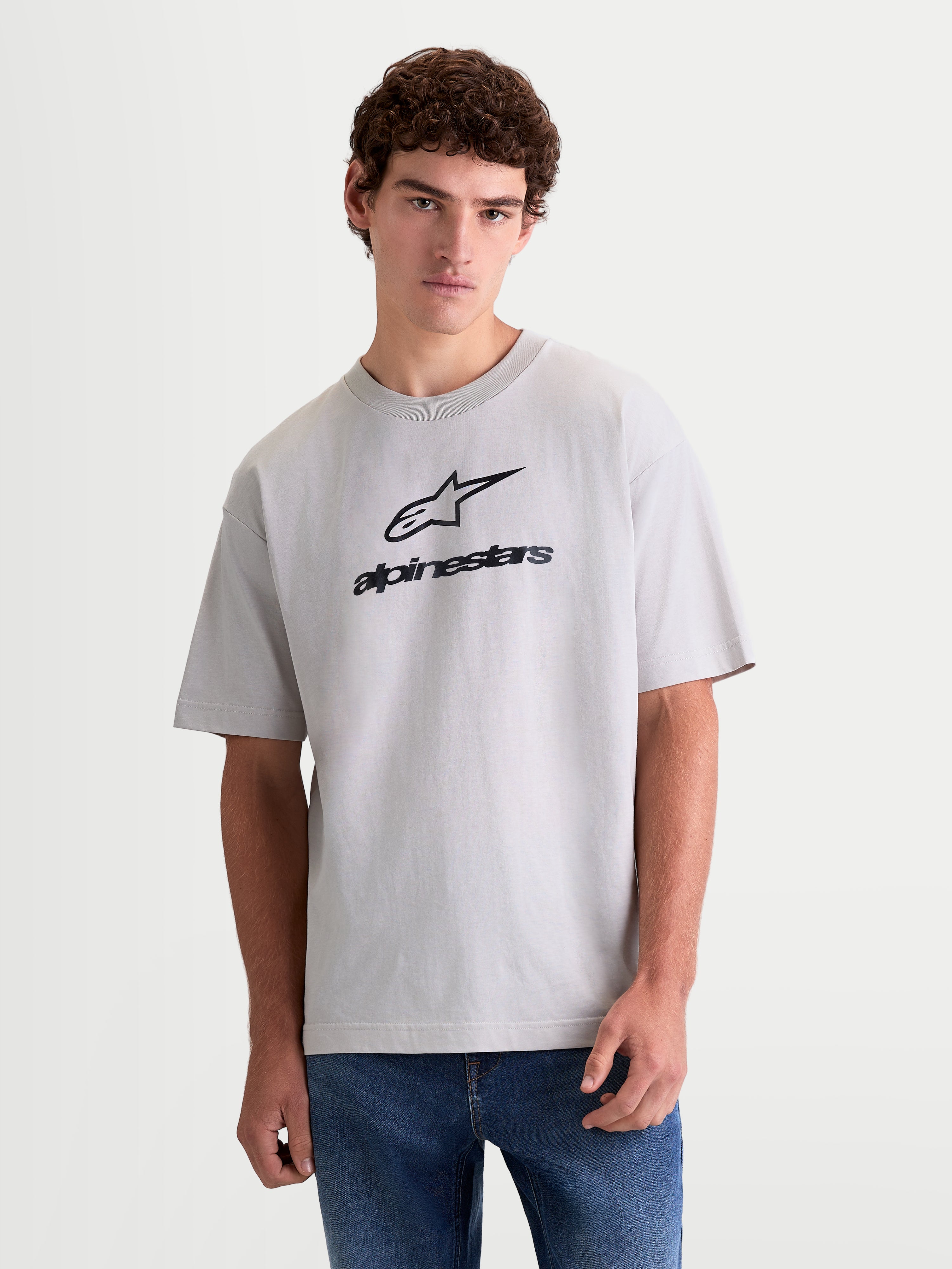 Alpinestars Prelude Oversized CSF, t-shirt de sportswear à manches courtes, gris ciment avec logo noir sur la poitrine, coupe large décontractée, vue de face sur mannequin