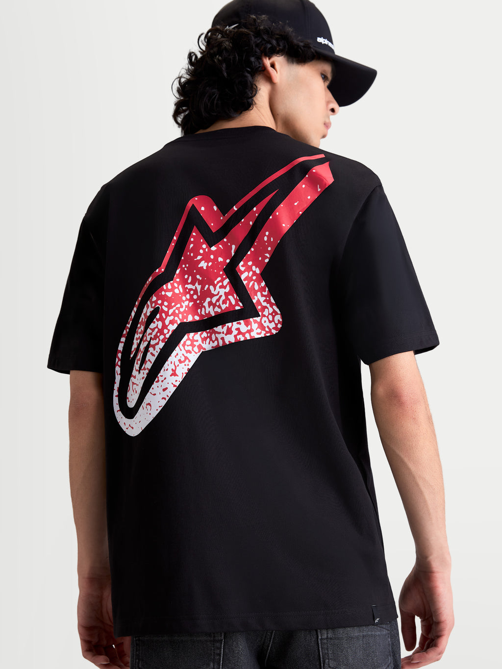 Alpinestars T-Shirt Meteor CSF, t-shirt sportswear noir à manches courtes, vue de dos montrant un grand logo Astars avec dégradé rouge et blanc inspiré du MX, style motorsport décontracté
