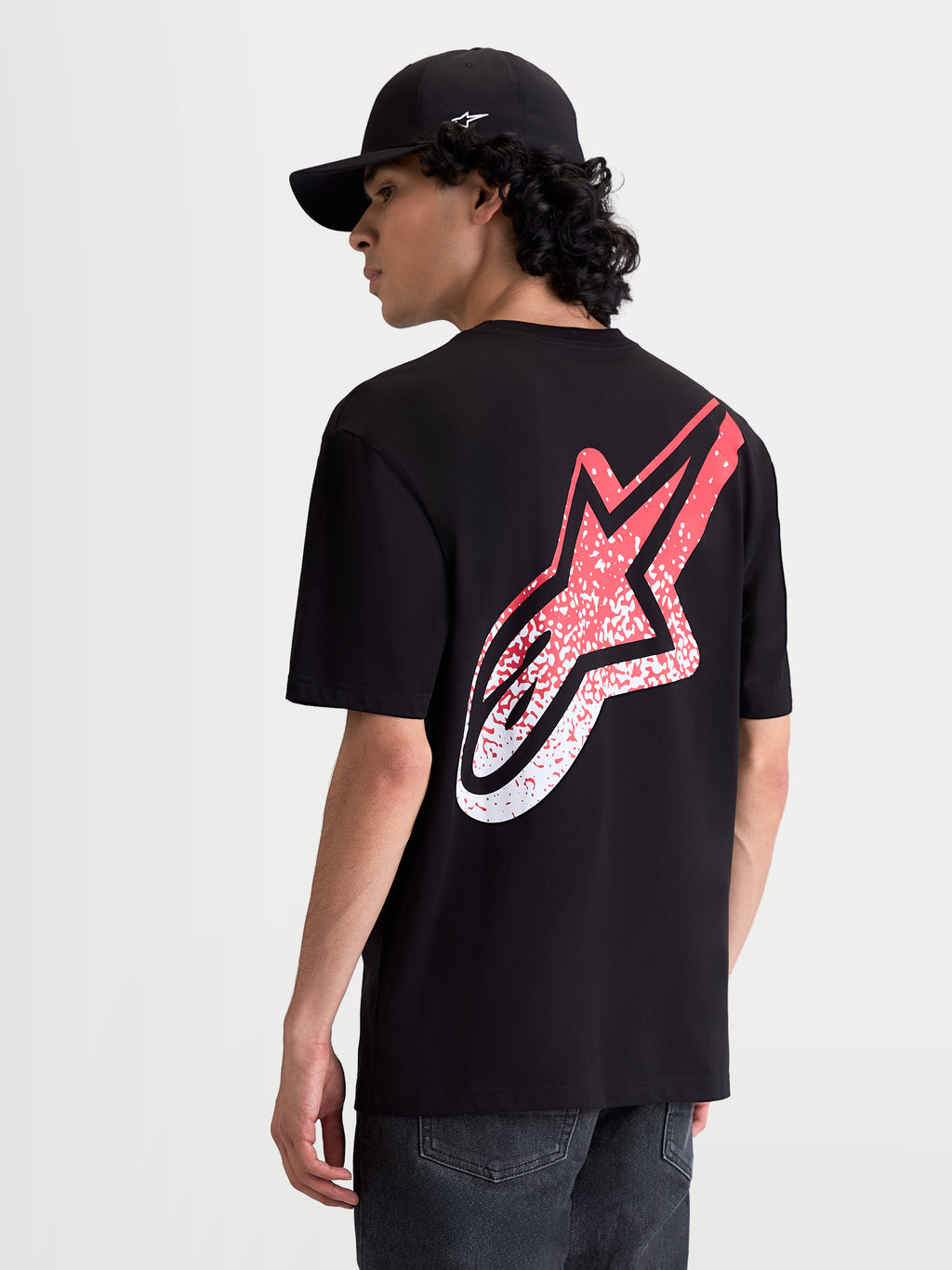 Alpinestars Meteor CSF, t-shirt sportswear pour homme à manches courtes, noir et rouge, vue de dos sur mannequin avec un grand logo Astars dégradé inspiré du motocross, mélange de coton et polyester pour un confort décontracté.
